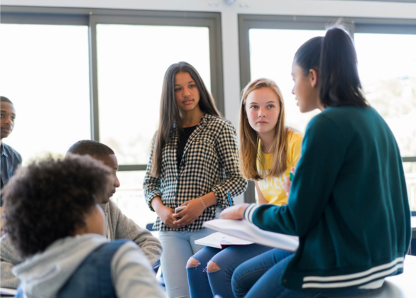 A group of youths having a discussion in a classroom