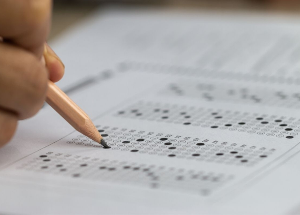 Student hand holding pencil for testing exam