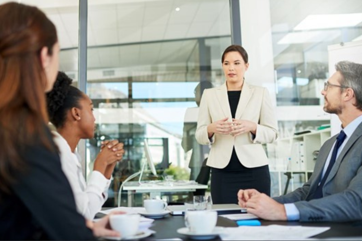 Colleagues discussing work around an office table 