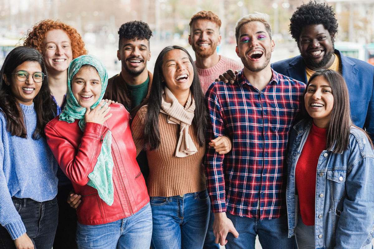 Young, diverse people laughing together outdoors 
