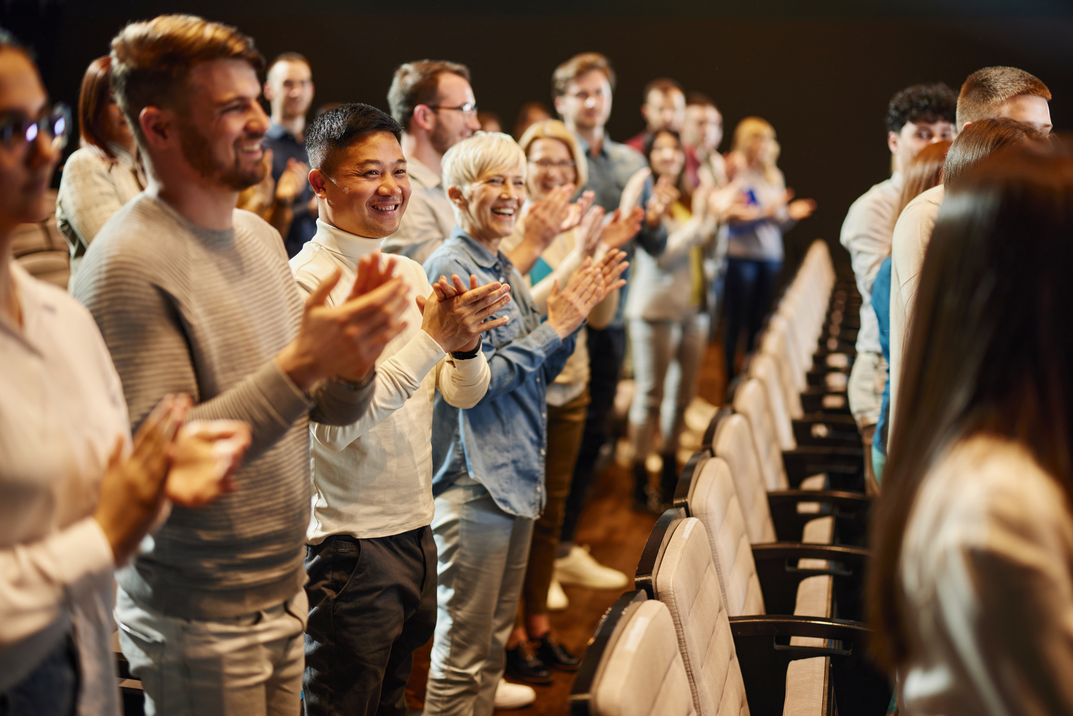 People standing and applauding in an auditorium