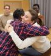 Two youth hugging in support group meeting