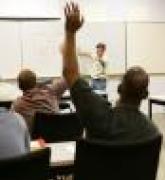 adult student in classroom with hand raised