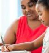 Young girl doing homework with mother