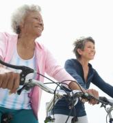 Senior female friends riding bicycle