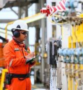 Operator recording operation of oil and gas process at oil and rig plant