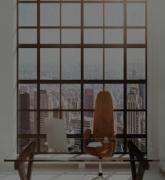 Office desk and chair in a white modern interior with city view