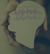 Adult and child hands holding encephalography brain paper cutout