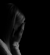 Black and white portrait of a woman hiding her face with hand