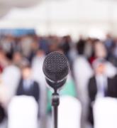 Microphone in focus against a blurred audience