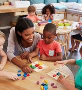 Teacher with preschool students at a desk