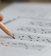 Student hand holding pencil for testing exam
