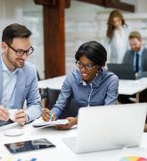 Two businesspeople reviewing business reports in the office.